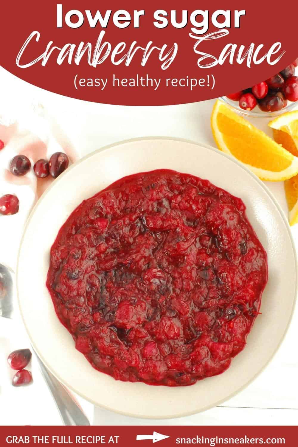 A bowl of healthy cranberry sauce next to a spoon, napkin, and fresh cranberries.
