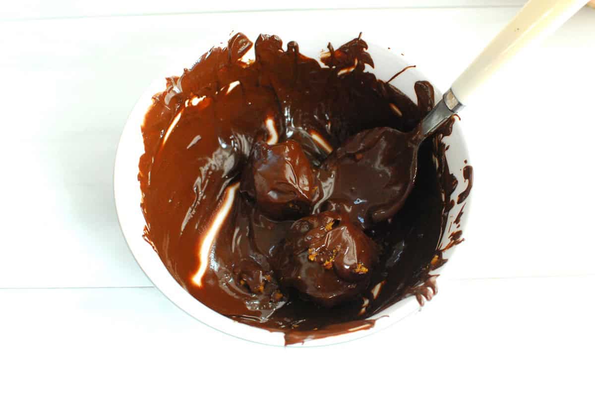 Rolling the filling balls in a bowl of melted chocolate.