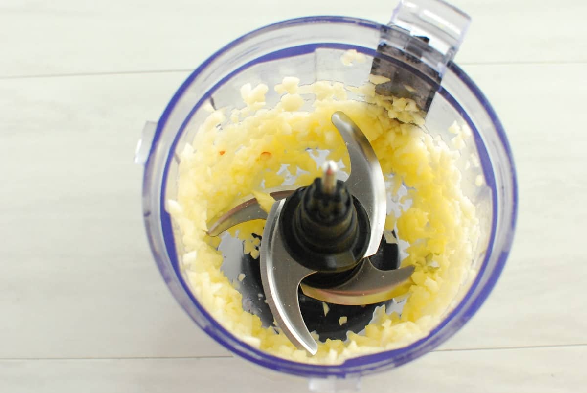 Grated apple in a food processor bowl.