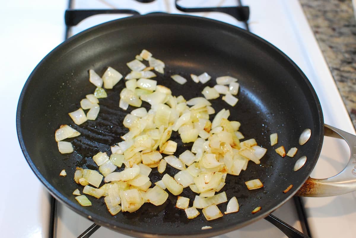 Onions sauteeing in a pan.