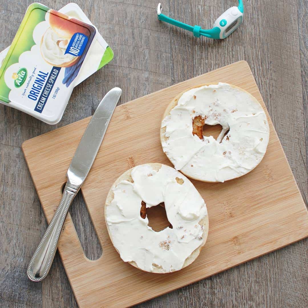 bagel with cream cheese on a cutting board