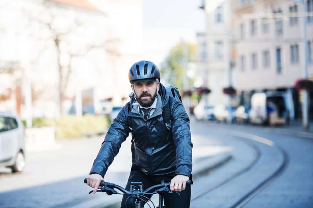 A man cycling to work on a cool day.