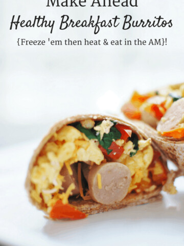 A make ahead breakfast burrito that's been cut in half on a white plate.