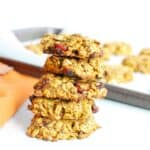 A stack of five pumpkin oatmeal breakfast cookies next to an orange napkin.