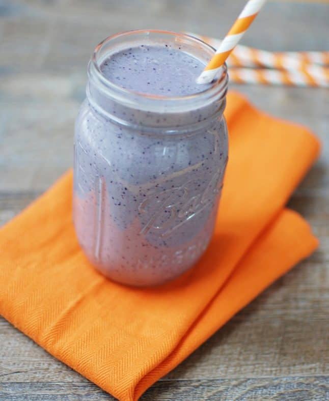 Wild blueberry pancake smoothie in a mason jar on an orange napkin