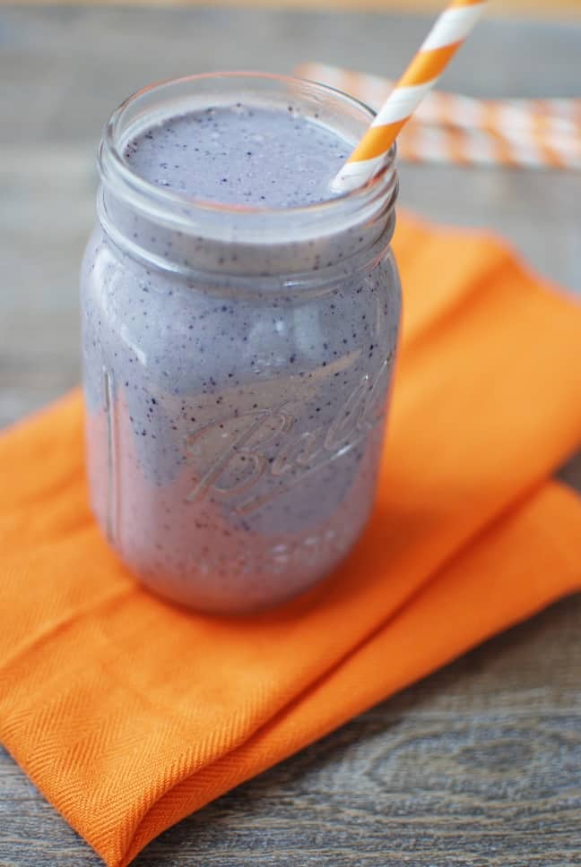 Blueberry green smoothie in a mason jar on a napkin