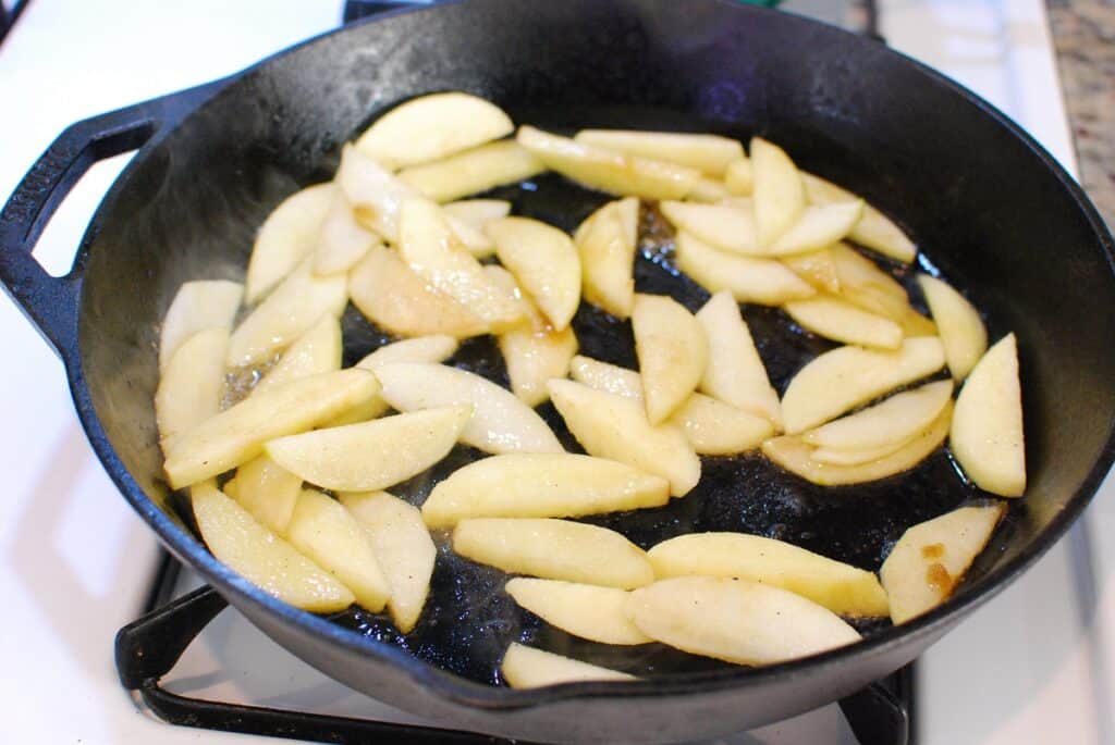 Apples being sautéed in a skillet.