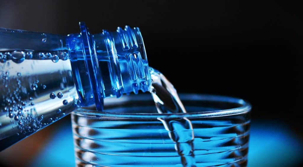 A water bottle being poured into a glass.