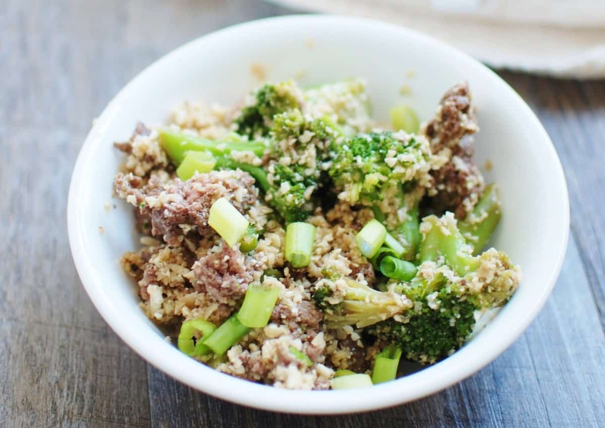 A bowl filled with soy-glazed beef, cauliflower rice, and broccoli.