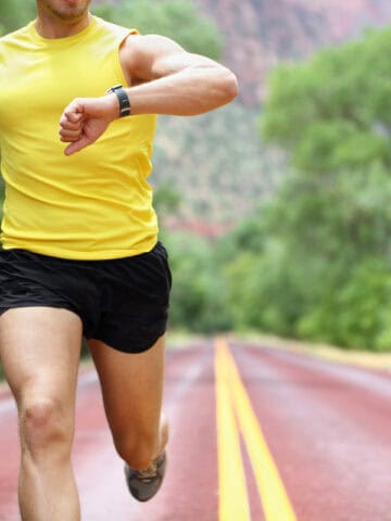 A runner attempting to conduct a lactate threshold field test on a paved road.