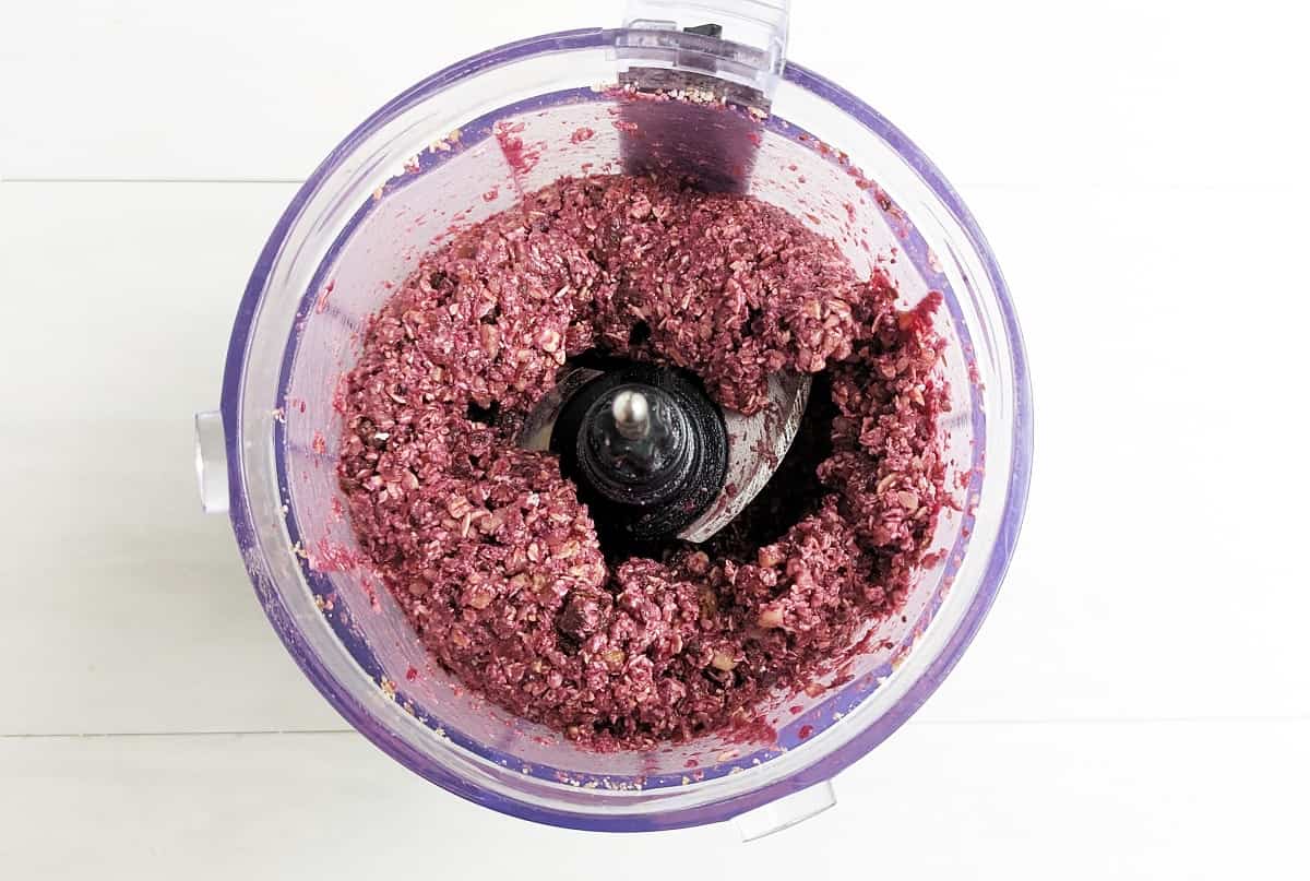 The chocolate cherry energy bite mixture in a food processor bowl.