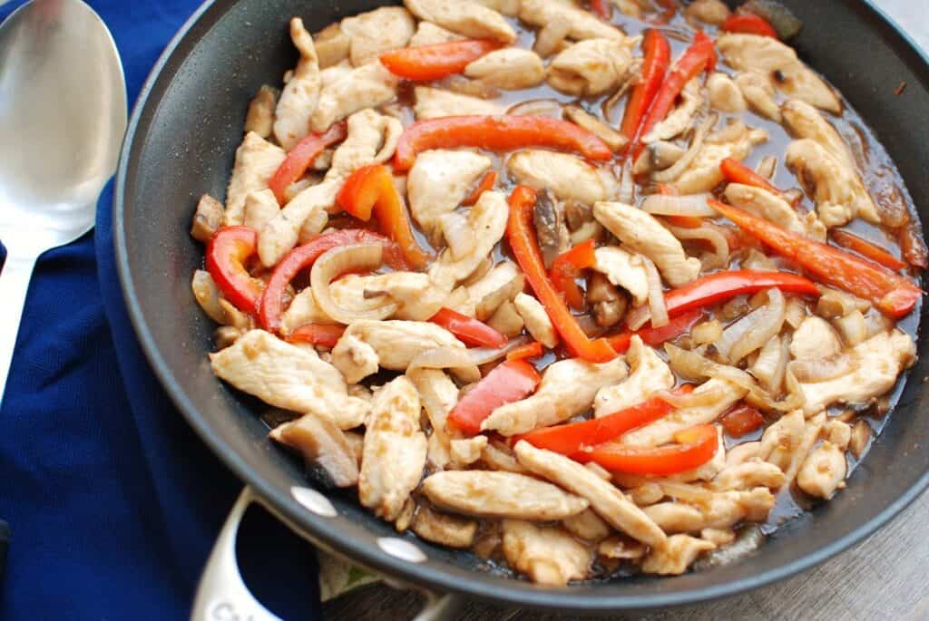 A pan with a chicken mushroom pepper stir fry.