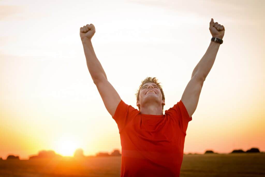 A man celebrating a fitness goal outside.