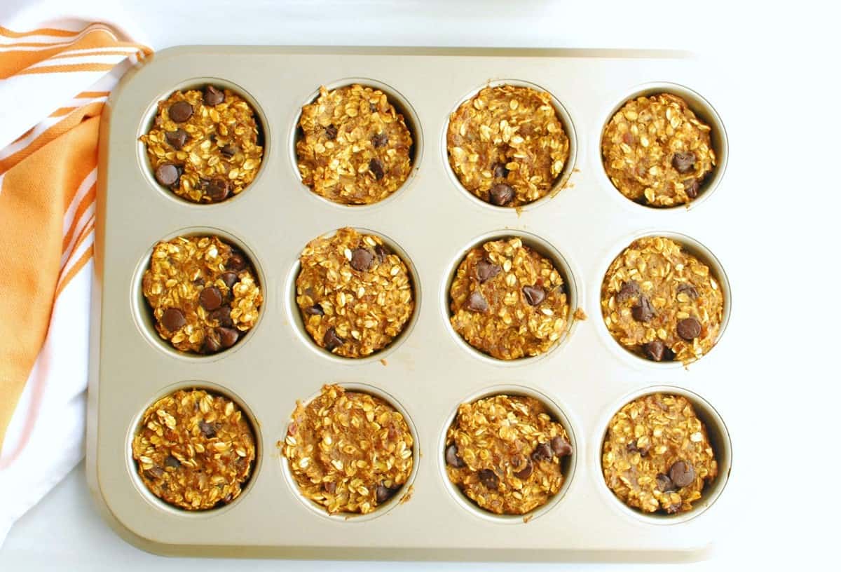 Baked pumpkin chocolate chip oatmeal cups in a muffin tin.