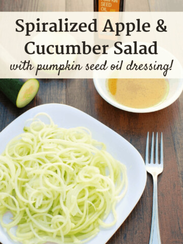 a white plate with apple cucumber salad next to a fork