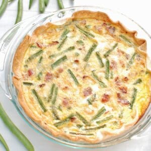 Green bean quiche baked in a glass pie plate.