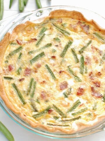 Green bean quiche baked in a glass pie plate.