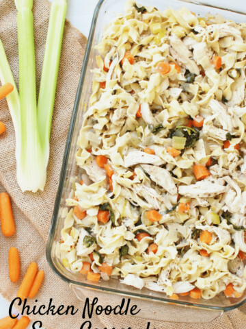 Chicken noodle soup casserole in a dish next to some celery and carrots