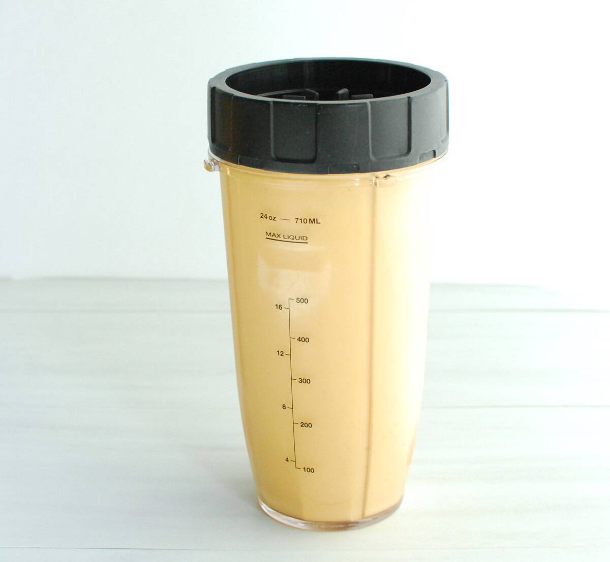 A blended turmeric banana smoothie in a blender cup.