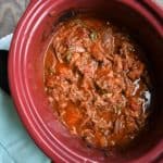 Ropa vieja in a red slow cooker dish