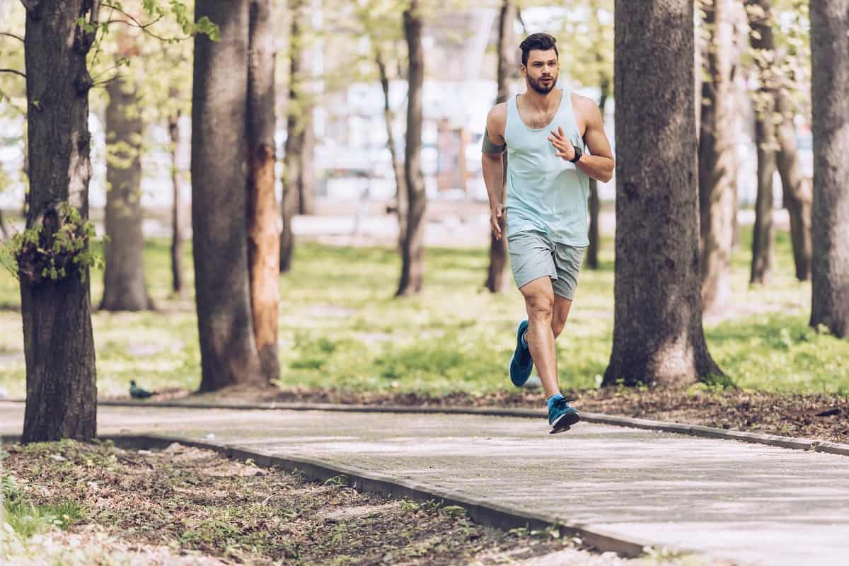 A man doing a fartlek run along a paved path.