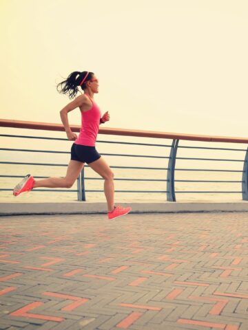 A woman sprinting on a brick path during a fartlek workout.