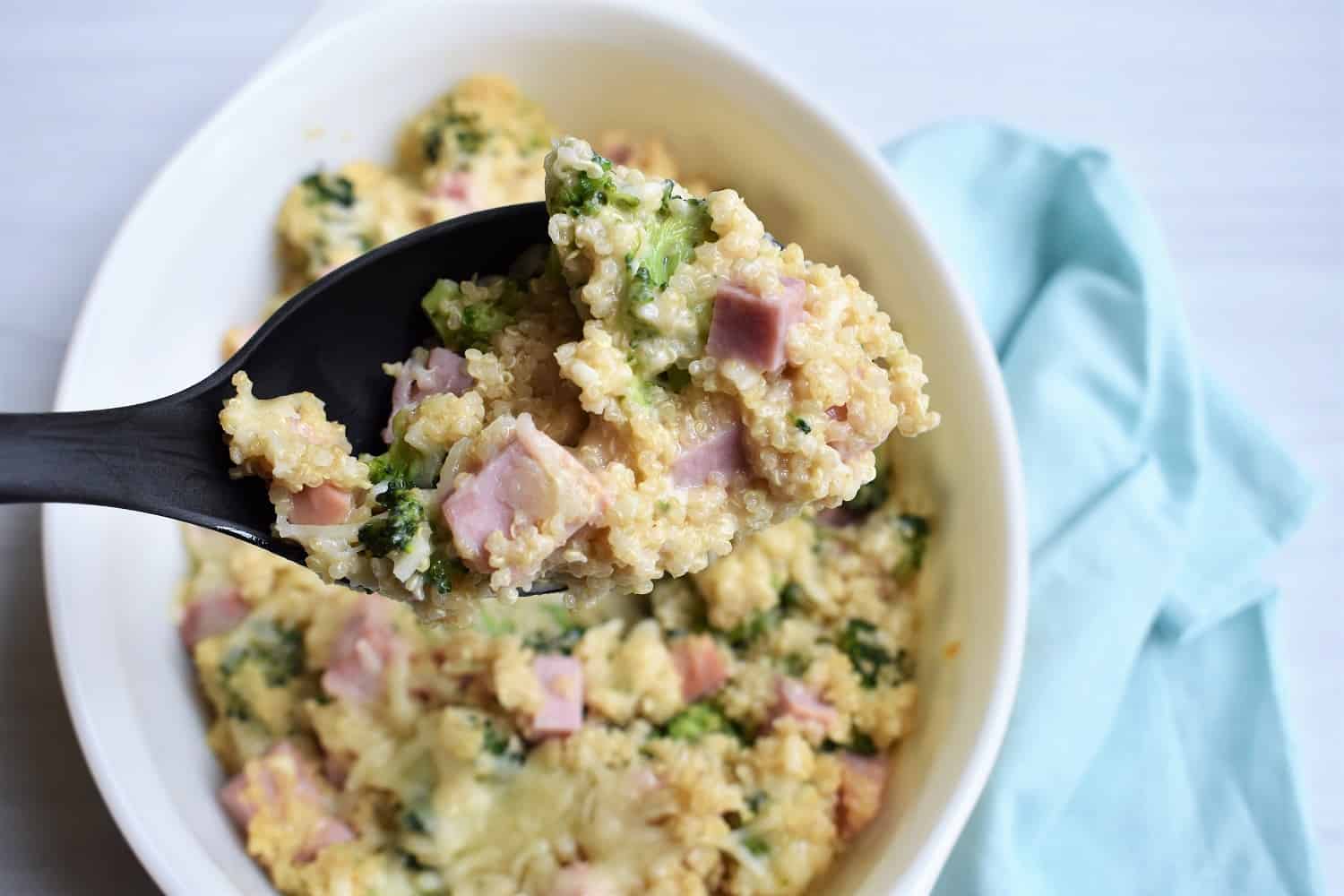 Spoonful of cheesy leftover ham casserole with quinoa and broccoli