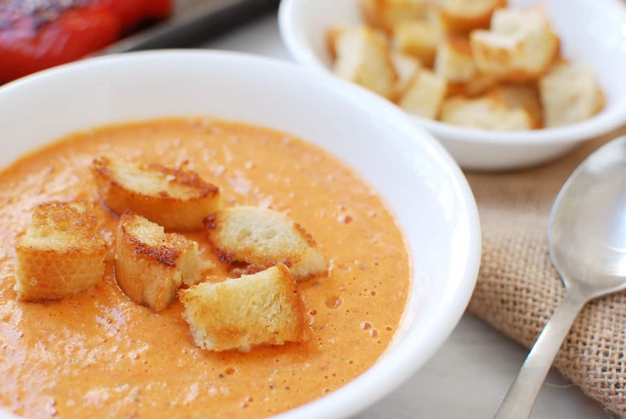 Bowl of Roasted Red Pepper and Gouda Soup topped with croutons