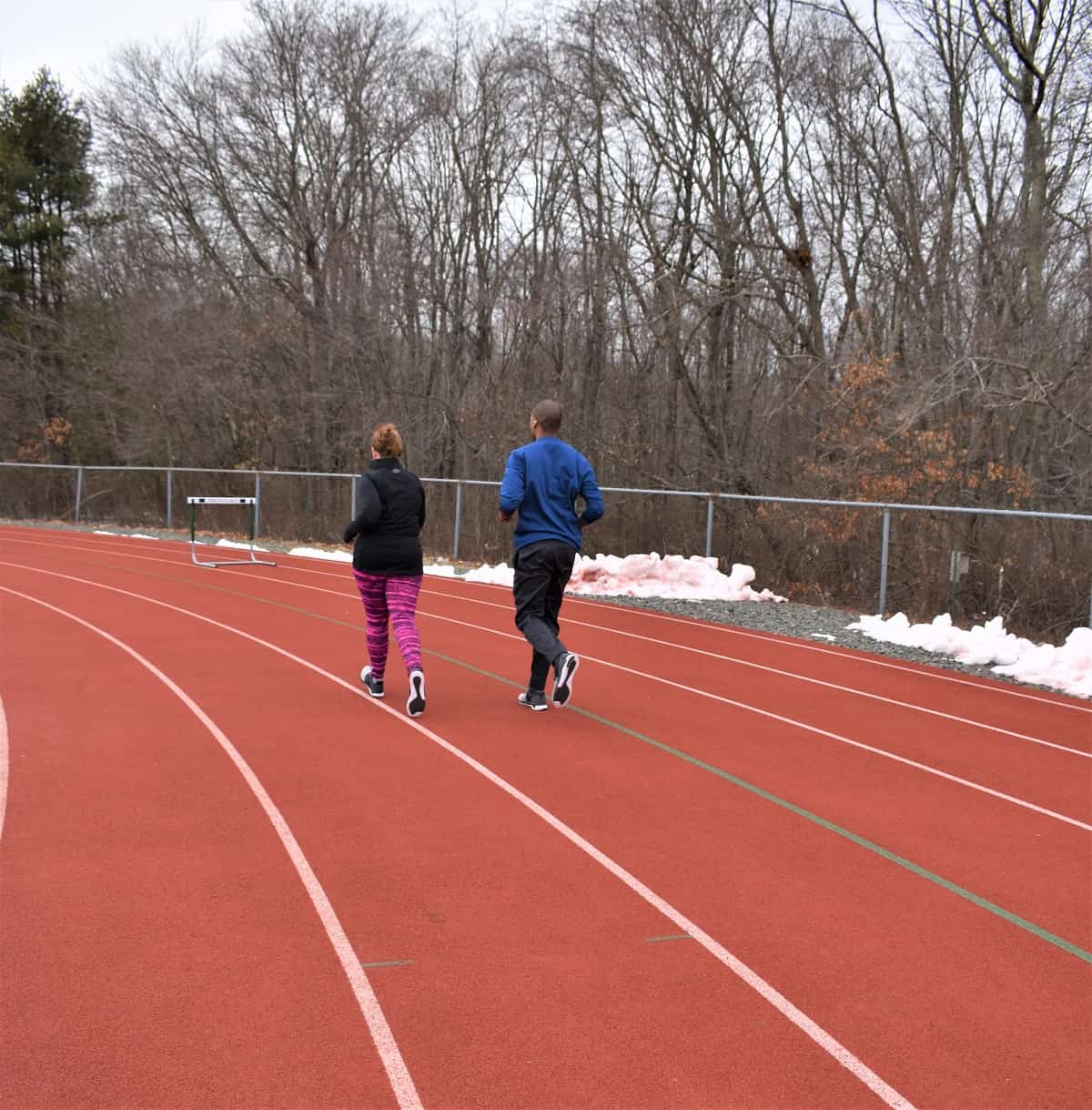 Couples running on a track in the winter