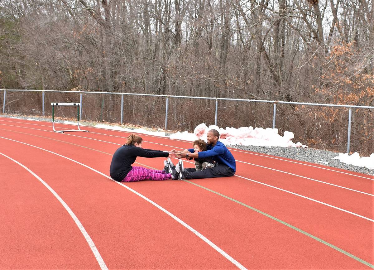 Couples stretching together on a track