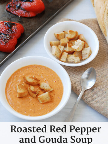 Roasted red pepper and gouda soup next to a bowl of croutons