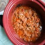 A slow cooker full of shredded beef.