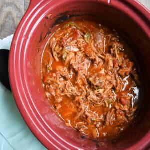 A slow cooker full of shredded beef.