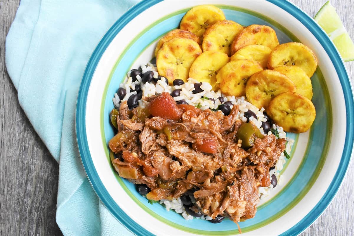 A bowl with rice, beans, shredded beef, and plantains.