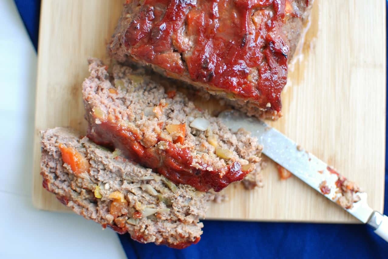 Green chile meatloaf on a cutting board with a few slices cut