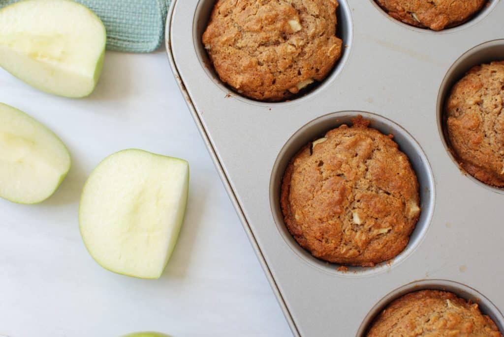 Vegan apple oat muffins in a muffin tin.
