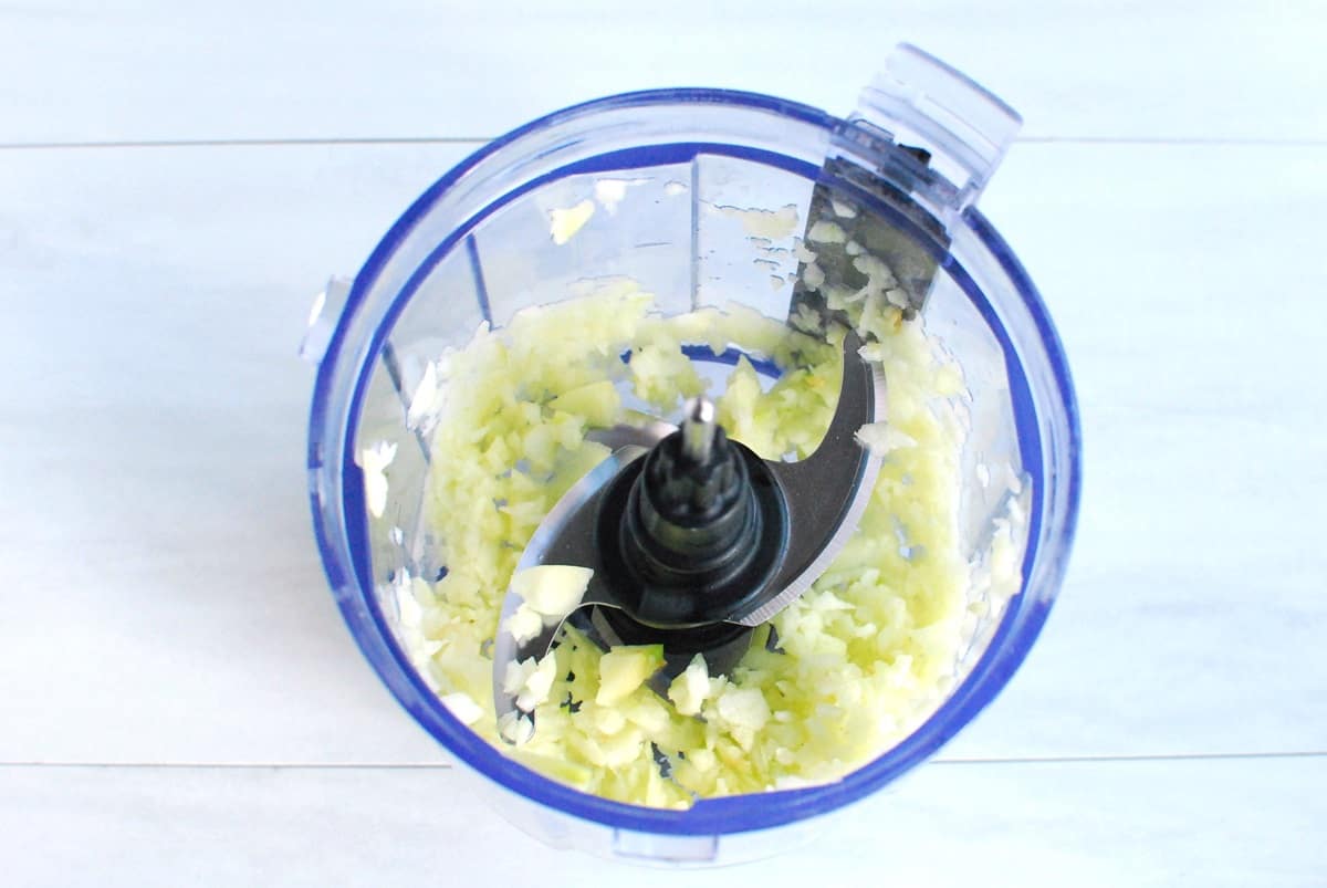 Apple grated in a food processor bowl.