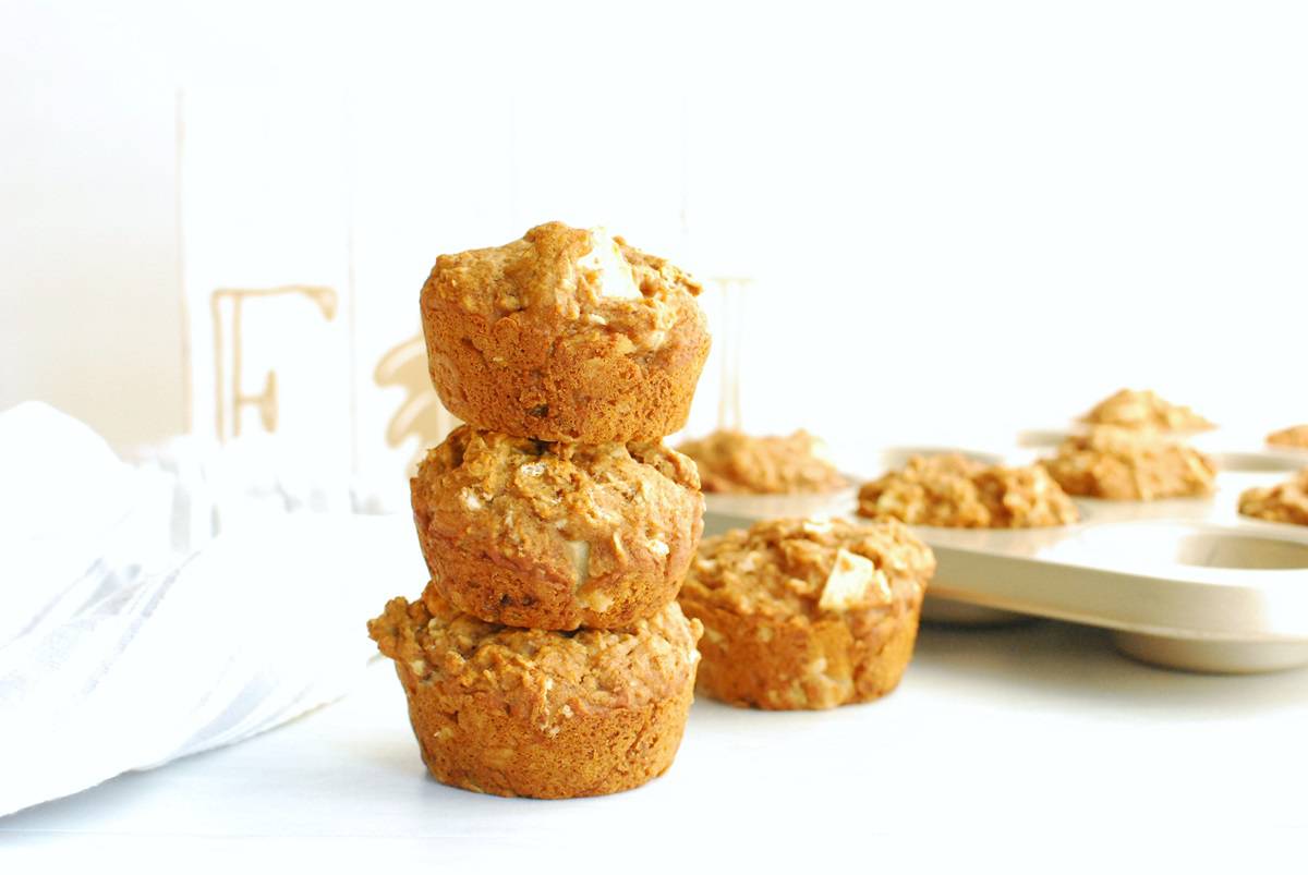 3 vegan apple muffins stacked on top of each other.