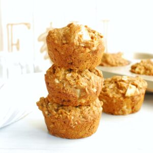 Several whole wheat vegan apple muffins stacked on top of each other.