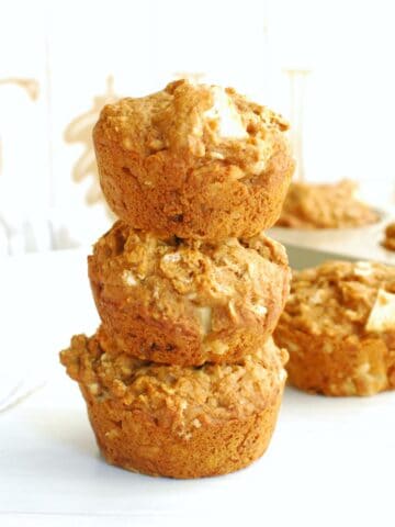 Several whole wheat vegan apple muffins stacked on top of each other.