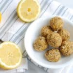 Lemon Coconut Energy Balls in a bowl next to lemons