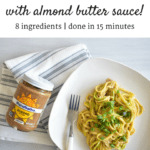 Zucchini noodles with almond butter sauce on a plate next to a jar of almond butter.