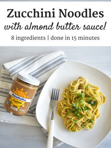 Zucchini noodles with almond butter sauce on a plate next to a jar of almond butter