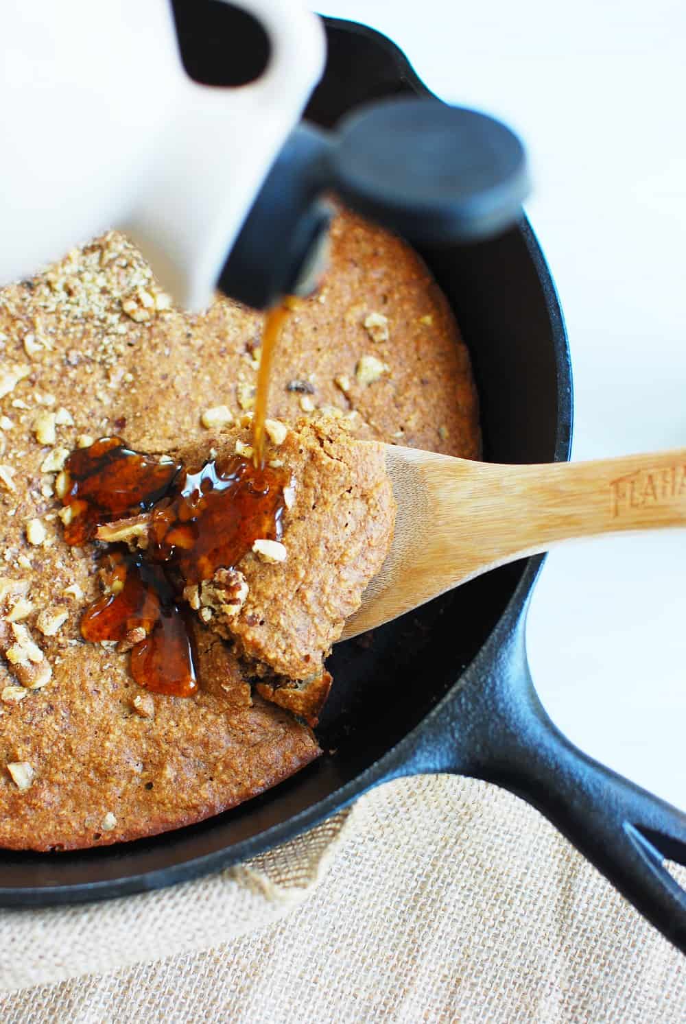 Cast iron skillet banana bread with maple syrup drizzled on top