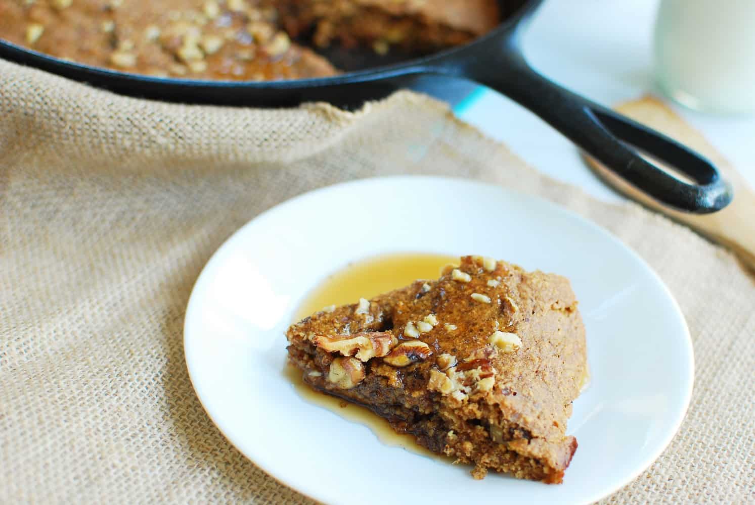 A plate with skillet banana bread topped with maple syrup