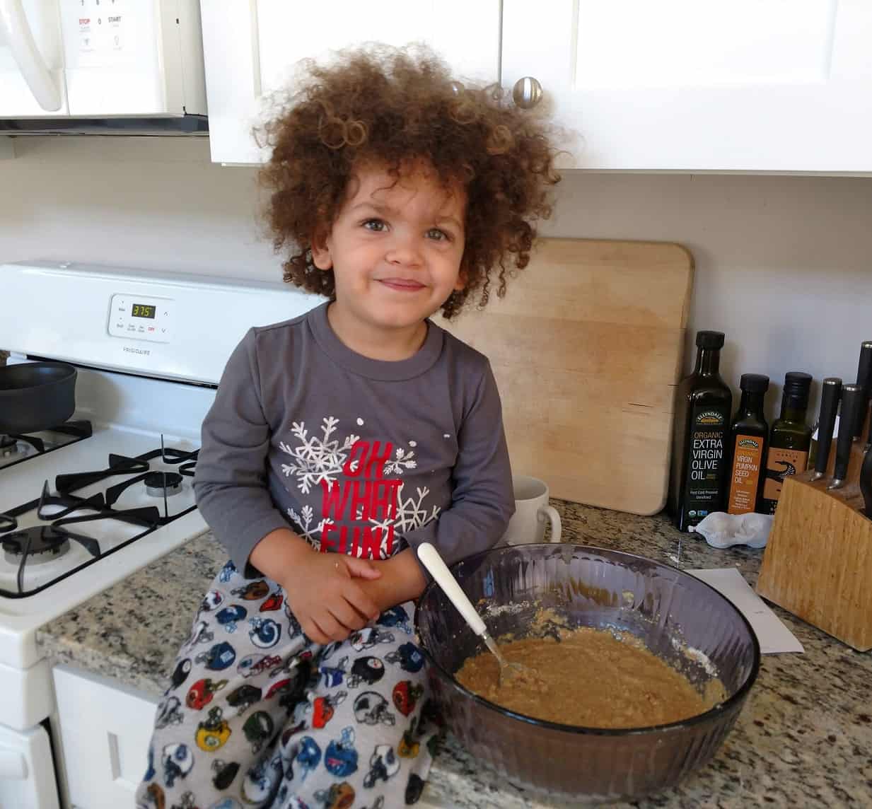 Little boy baking in the kitchen in pajamas