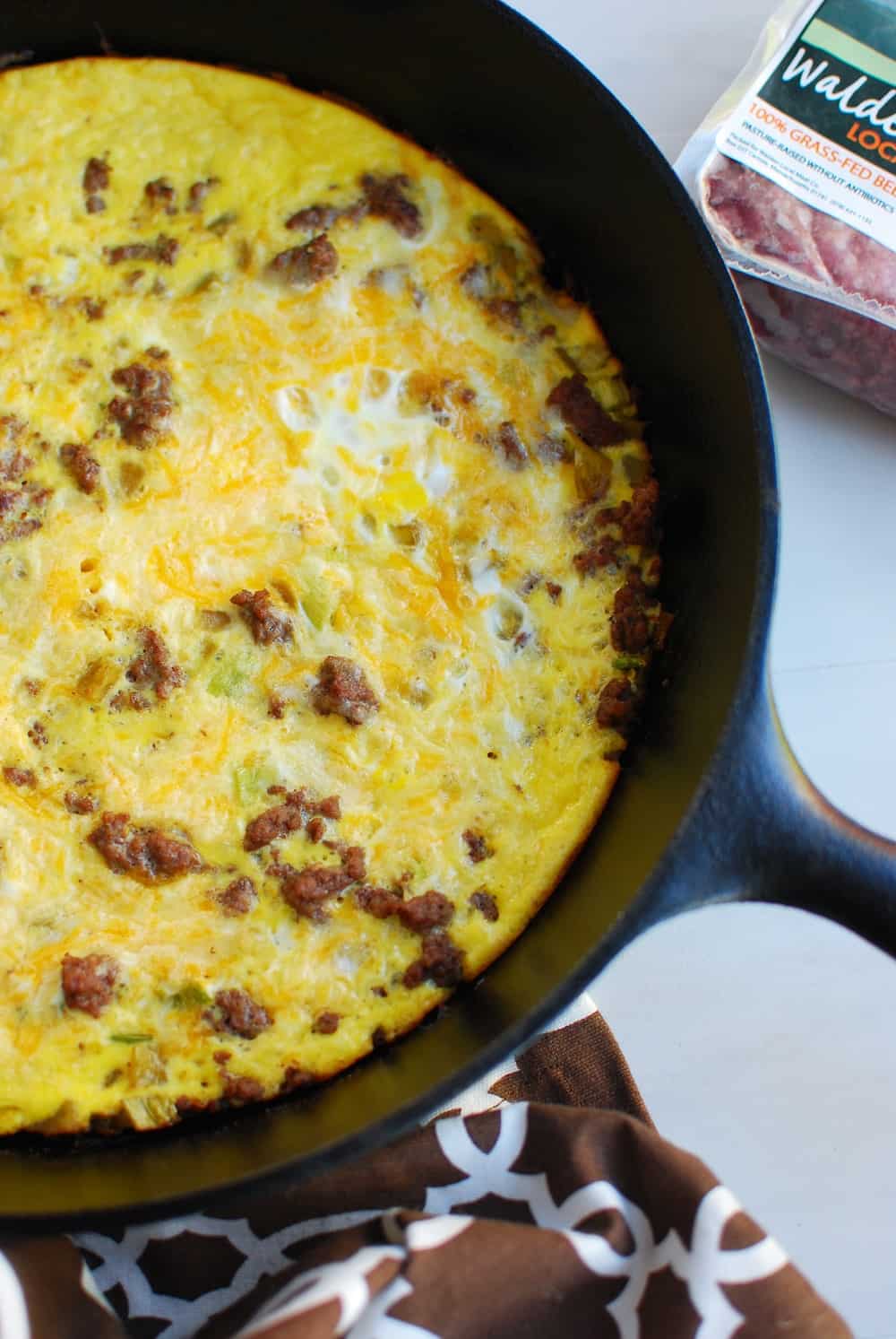 Keto frittata made with eggs, cheese, ground beef, scallions, and chiles