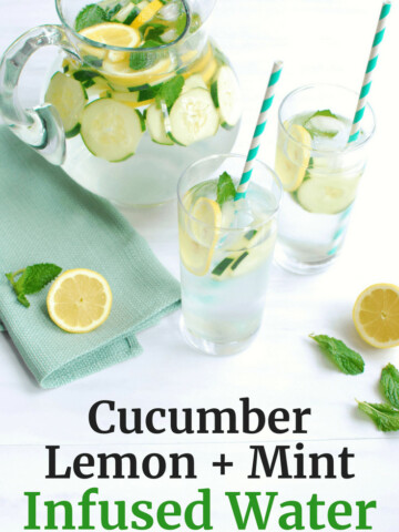 Pitcher full of cucumber lemon mint water, next to a sliced lemon