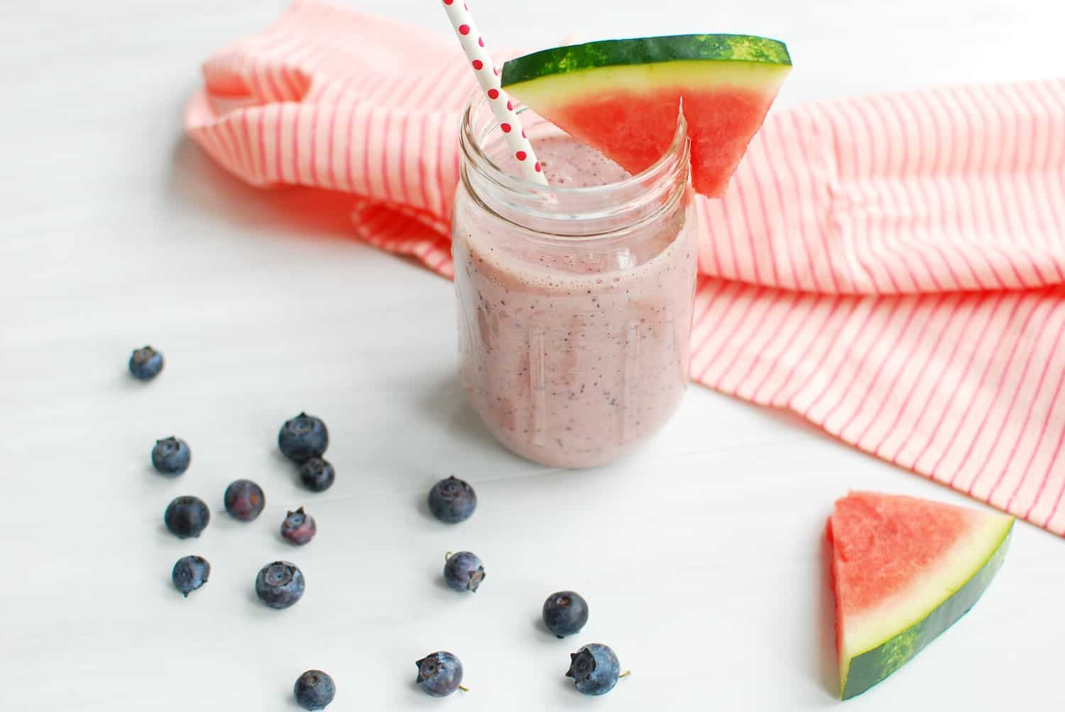 Watermelon blueberry smoothie next to some blueberries