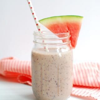 Watermelon blueberry smoothie with a slice of watermelon on the rim